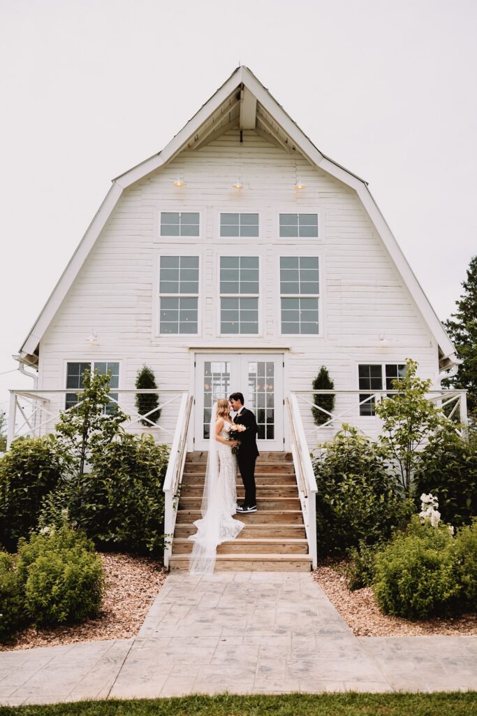 Bride and Groom on steps at Ivory North Co wedding venue in Mora Minnesota